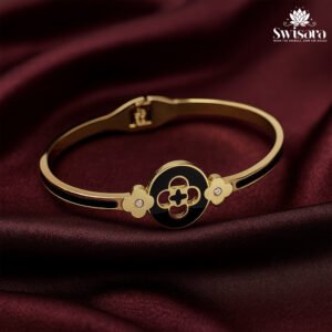 Onyx Emblem Bangle with gold-tone finish, black enamel centerpiece, clover motifs, and crystal accents – Swisara